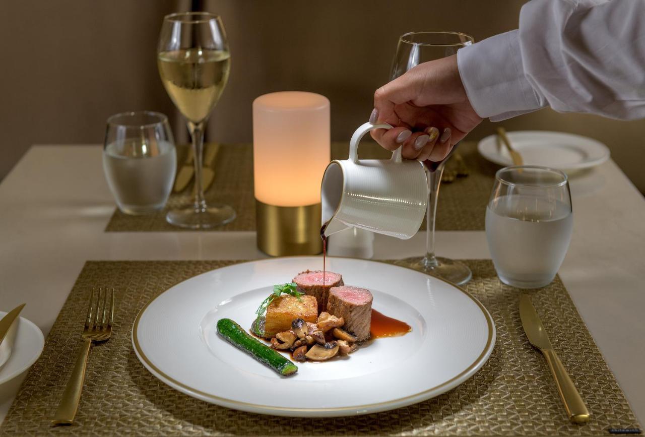 ホテル Amarande (Adults Only) アヤナパ エクステリア 写真 A server pouring sauce onto a plate of food